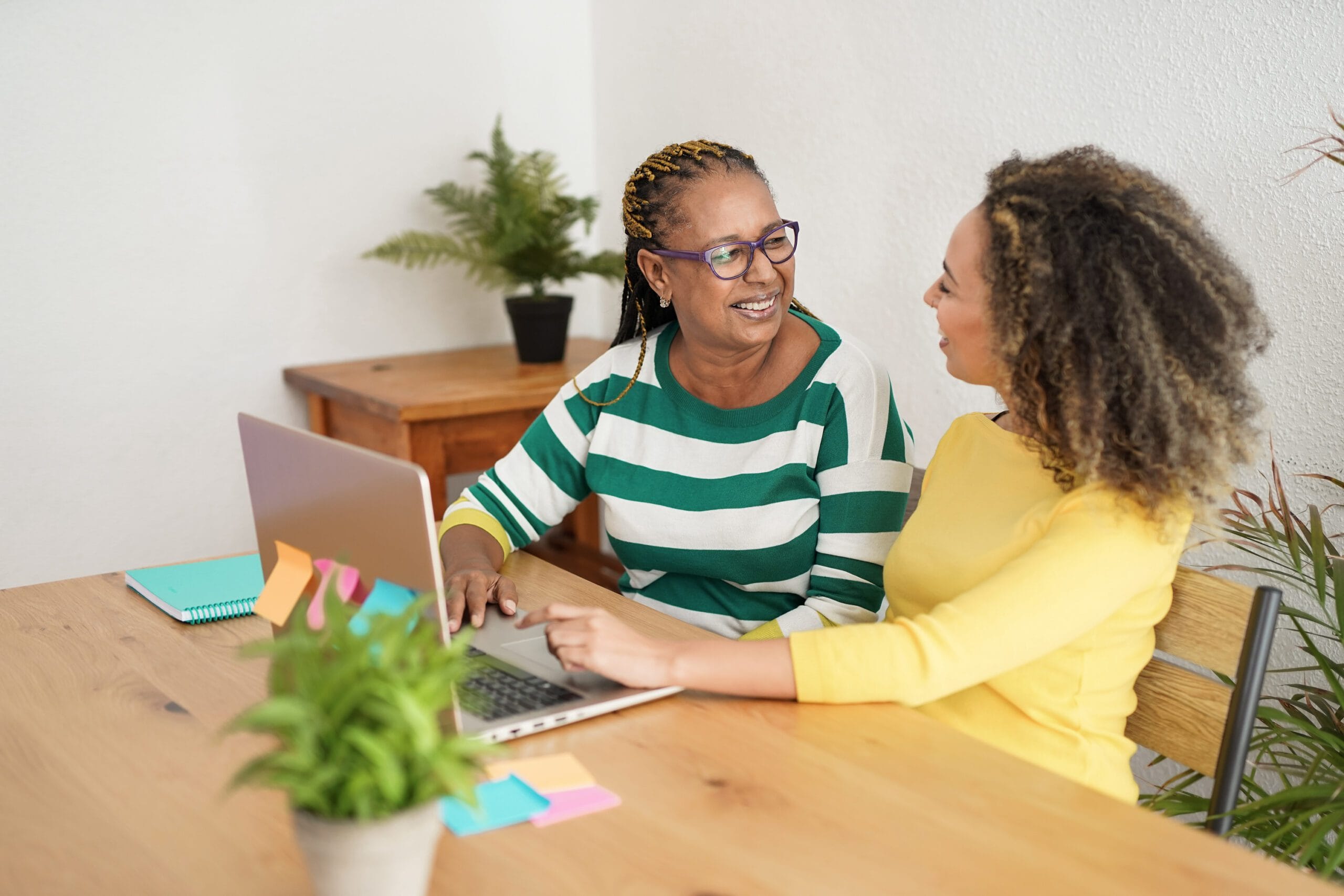 Deux femmes souriant devant un ordinateur